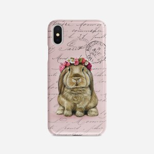 May include: A phone case featuring a brown bunny wearing a floral crown, set against a pink background with script and stamps. The case has a glossy finish and a camera cutout.