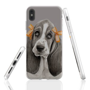 May include: A clear phone case with a gray background and a black and white illustration of a basset hound puppy wearing orange bows.