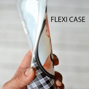 Puede incluir: Una funda para tel&eacute;fono de cuadros negros y blancos con la parte posterior transparente. La funda es flexible y tiene un borde elevado para proteger la pantalla. El texto "FLEXI CASE" est&aacute; impreso en la funda.