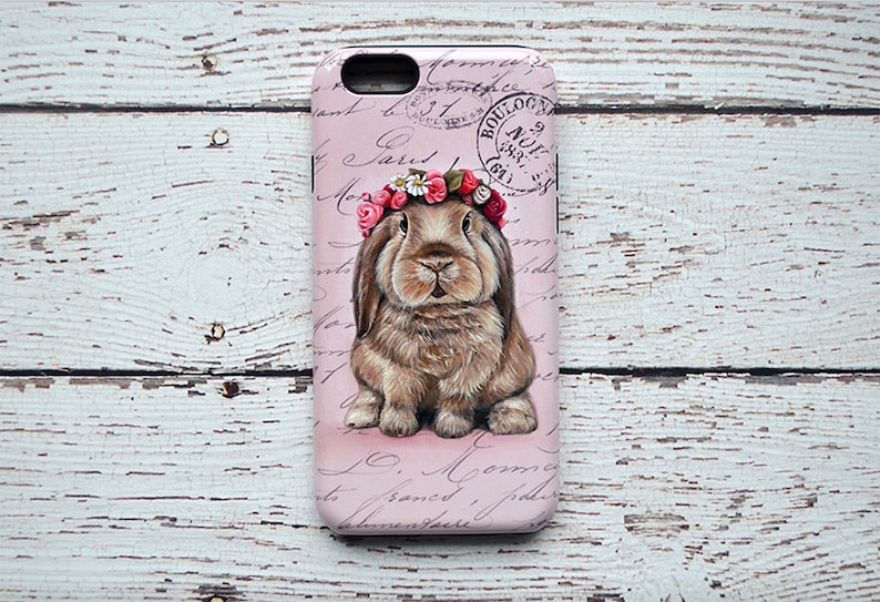May include: A pink phone case featuring a detailed illustration of a brown rabbit wearing a floral crown. The case has a vintage aesthetic with script and a stamp that reads "BOULOGNE".