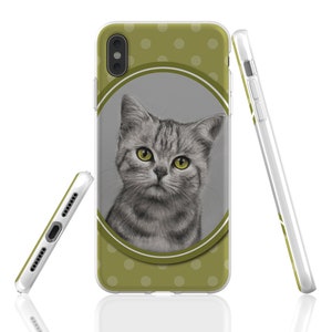 May include: A green phone case with white polka dots and a drawing of a grey cat with yellow eyes inside a circle.