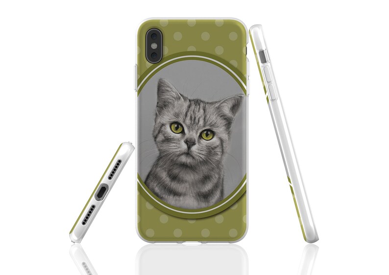 May include: A green phone case with white polka dots and a drawing of a grey cat with yellow eyes inside a circle.