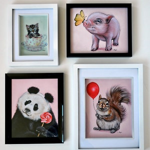 Puede incluir: Cuatro pinturas enmarcadas con fondos rosas. La pintura de la parte superior izquierda muestra un gatito blanco y negro sentado en una taza de t&eacute; rosa y blanca con lunares. La pintura de la parte superior derecha muestra un lech&oacute;n rosado mirando una mariposa amarilla. La pintura de la parte inferior izquierda muestra un panda blanco y negro sosteniendo una piruleta roja y blanca. La pintura de la parte inferior derecha muestra una ardilla gris sosteniendo un globo rojo.