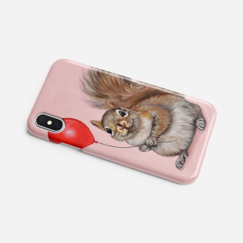 May include: A pink phone case with a cartoon squirrel holding a red balloon. The squirrel is brown and gray with a bushy tail.