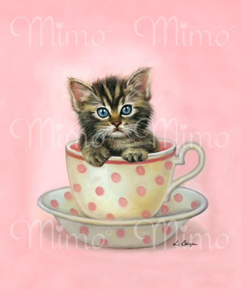 Puede incluir: Un lindo gatito tabby con ojos azules se sienta dentro de una taza de t&eacute; blanca con lunares rosas. La taza de t&eacute; est&aacute; sobre un platillo a juego. El fondo es rosa.