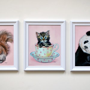 Puede incluir: Tres pinturas enmarcadas con fondos rosas. La primera pintura presenta una ardilla sosteniendo un globo rojo. La segunda pintura presenta un gatito sentado en una taza de t&eacute;. La tercera pintura presenta un panda sosteniendo una piruleta rosa.