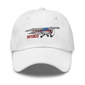 May include: White baseball cap with an embroidered red, white, and blue airplane with the tail number N1903.