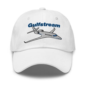 Puede incluir: Gorra de béisbol blanca con una imagen bordada de un avión privado Gulfstream y el texto "Gulfstream" en azul.