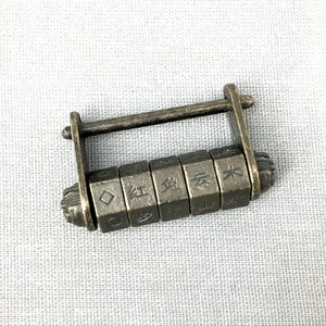 Op de afbeelding: Een vintage-stijl combinatiepad met een messing afwerking. Het slot heeft een reeks draaibare wijzerplaten met Chinese karakters.