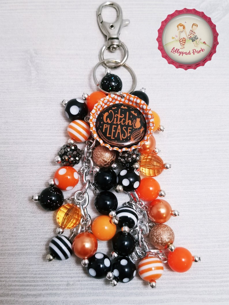 May include: A Halloween-themed keychain with a black and orange bottle cap charm that says "Witch Please". The keychain also features a variety of black, orange, and white beads.