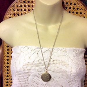 Monogrammed gold metal locket BDE.