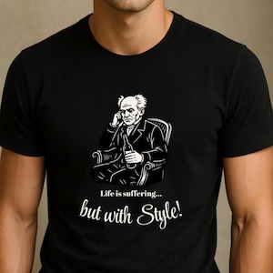 May include: Black t-shirt with a black and white illustration of a man in a chair holding a bottle. The text "Life is suffering... but with Style!" is printed below the illustration.