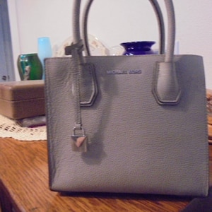 Bolso de mano tipo cartera pequeño en color gris de Michael Kors