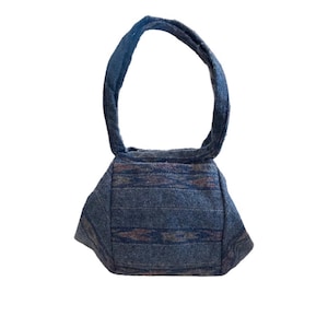 May include: A small blue and brown patterned tote bag with a single handle.