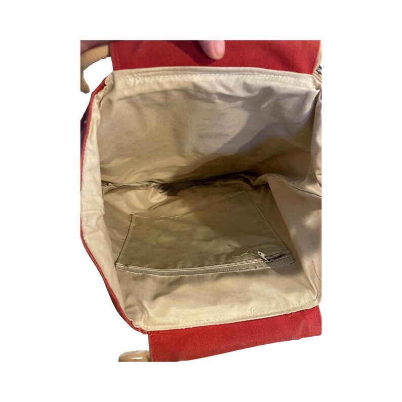 May include: Red canvas tote bag with a zippered pocket on the inside. The bag is empty and the inside is visible.