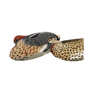 May include: Two fabric duck-shaped pillows with a brown, green, and red patterned design.