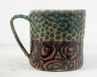 ceramic coffee cup in shino with green polka dots and purple concentric circles