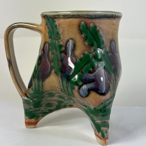 Taza de trípode en Shino con flores azules y moradas