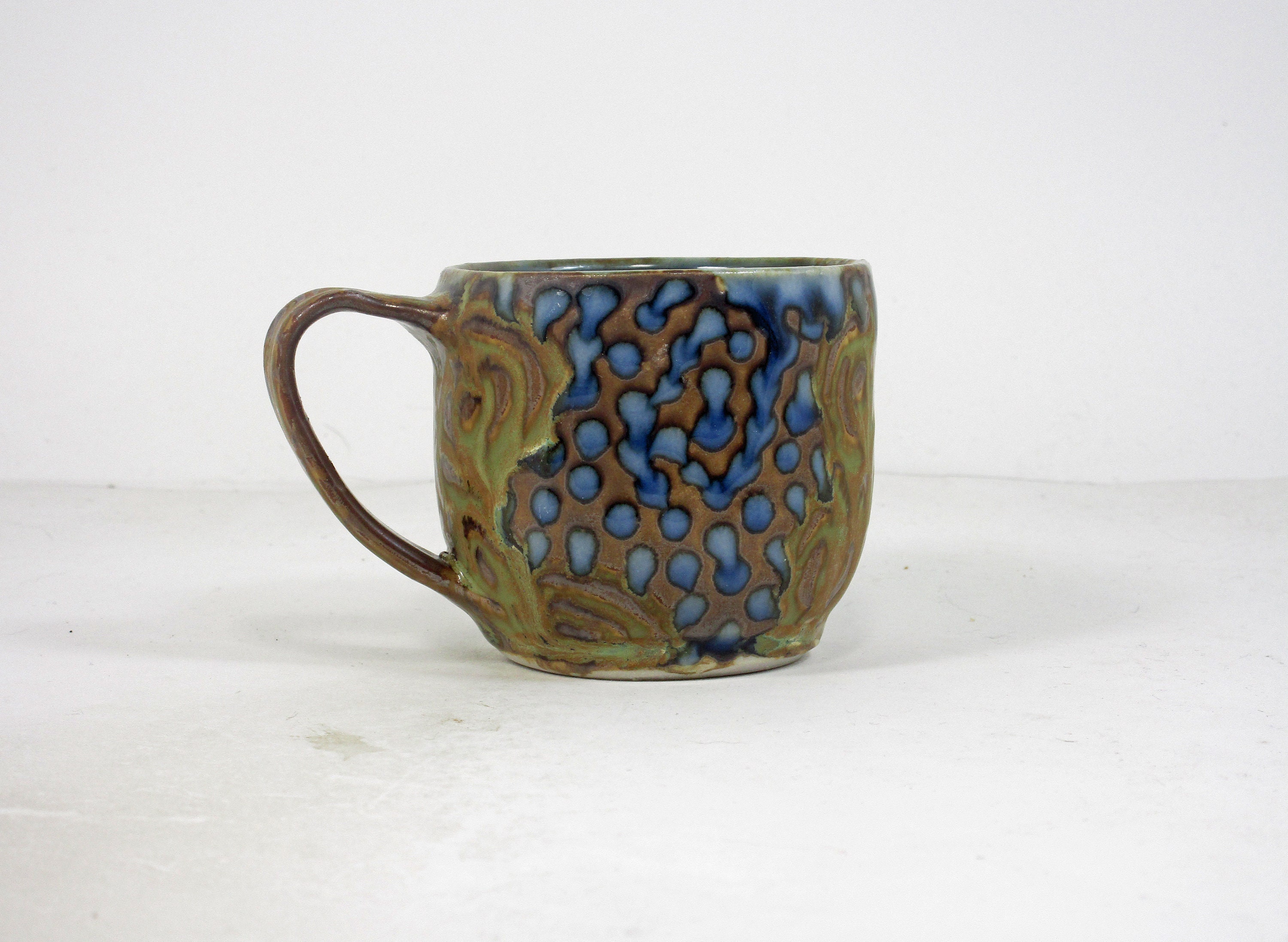 coffee cup in walnut brown with rust and emerald green concentric circle