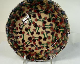 Ceramic pie plate in Shino with red and purple flowers