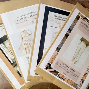 May include: Four brown paper envelopes with printed sewing patterns inside. The patterns include a dress, a shirt, pants, and a cardigan. The envelopes are stacked on top of each other.
