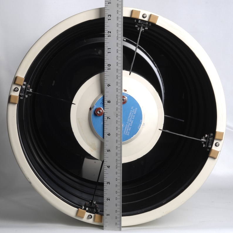 May include: A white speaker with a black cone and a blue label that reads "Lectron Electronics Co.  Model 1200  Made in U.S.A.". The speaker is 12 inches in diameter and has a ruler next to it for scale.