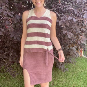 Può includere: Un set di top e gonna a maglia a righe in color malva e crema. Il top ha una scollatura a V e la gonna ha uno spacco laterale e un nodo in vita.