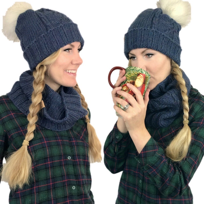May include: Two women wearing blue knitted hats with white pom-poms and matching blue knitted scarves. Both women are wearing plaid shirts and have their hair in braids.