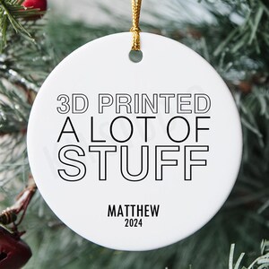 May include: White ceramic Christmas bauble with black text that reads "3D Printed A Lot Of Stuff" and "Matthew 2024".