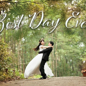 May include: A bride and groom are embracing in a woodland setting. The bride is wearing a white wedding dress and the groom is wearing a black suit. The text "Best Day Ever" is written in white cursive letters above them.