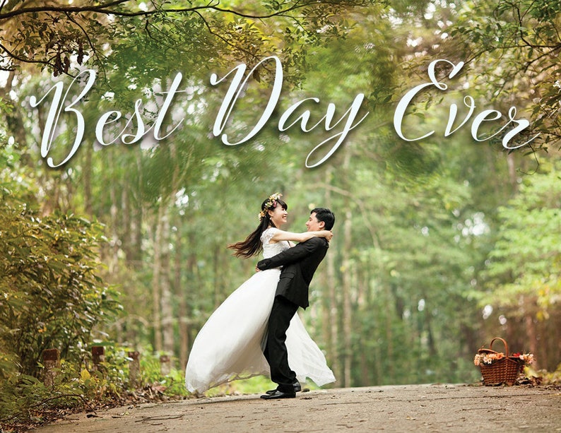 May include: A bride and groom are embracing in a woodland setting. The bride is wearing a white wedding dress and the groom is wearing a black suit. The text "Best Day Ever" is written in white cursive letters above them.