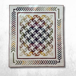 May include: A rectangular quilt featuring a central pattern of interlocking, swirling shapes in variegated shades of burgundy, gold, olive green, and navy blue against a white background, framed by a dark red border and a chevron-patterned edge.