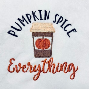 May include: White embroidered tote bag with the text "Pumpkin Spice Everything" in black and orange. A brown coffee cup with a pumpkin inside is embroidered in the center.