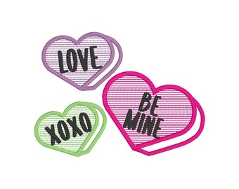 Könnte beinhalten: Drei herzförmige Valentinstagsdekorationen in Form von Bonbons mit gestreiften Mustern. Die Herzen sagen "LOVE", "XOXO" und "BE MINE".