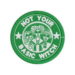 Puede incluir: Parche bordado verde con contorno blanco. El parche presenta tres brujas con un fondo verde y el texto "NOT YOUR BASIC WITCH" en un círculo.