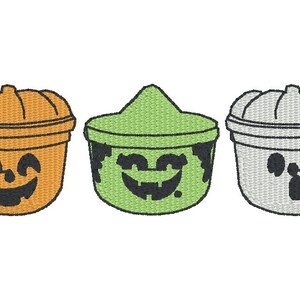 Op de afbeelding: Drie Halloween-snoep emmers met verschillende gezichten. De eerste emmer is oranje met een pompoengezicht, de tweede is groen met een heksengezicht en de derde is grijs met een spookgezicht.