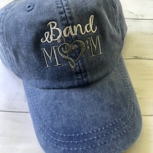 May include: A blue denim baseball cap with the embroidered text "Band Mom" and a musical note in a heart.