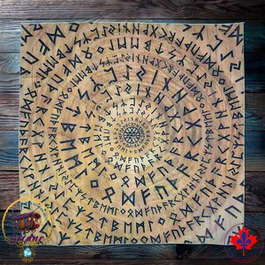 May include: A square fabric tapestry featuring a light tan background with a dark brown wood grain texture. The surface is printed with multiple concentric circles of black runic characters, with a small circular geometric design at the centre.