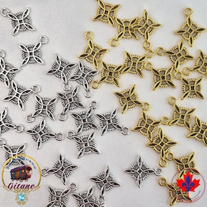 Peut inclure: Une collection de breloques en métal aux tons argentés et dorés, chacune présentant un motif de nœud à quatre branches avec un carré central et de petites boucles de fixation. Les breloques sont éparpillées, révélant des textures torsadées.