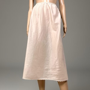 May include: A white ceramic mug with a black handle and the text "But First, Coffee" in a black, handwritten-style font. The mug is on a white surface.