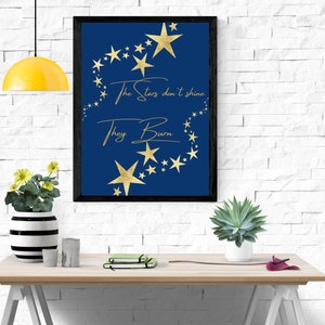 Könnte beinhalten: Ein marineblaues Poster mit goldenen Sternen aus Folie und dem Text "The stars don't shine, they burn".