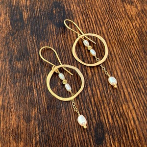 14k gouden pareloorbellen.  Massief gouden hangoorbellen met witte zoetwaterparels.