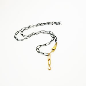Collier en argent et en or. Collier chaîne trombone à fermeture sur le devant en argent oxydé et or 14 carats.