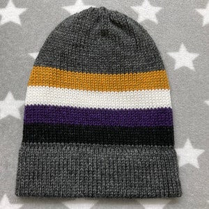 May include: Gray knit beanie with a striped pattern in yellow, white, purple, black, and gray.