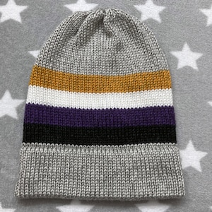 May include: A gray knitted beanie with a striped pattern in gold, white, purple, black, and gray.