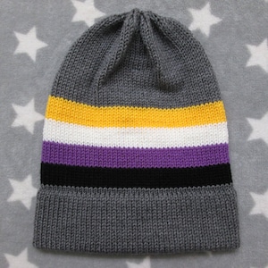 May include: Gray knitted beanie with yellow, white, purple, and black stripes. The beanie is made of soft, warm yarn and is perfect for cold weather.
