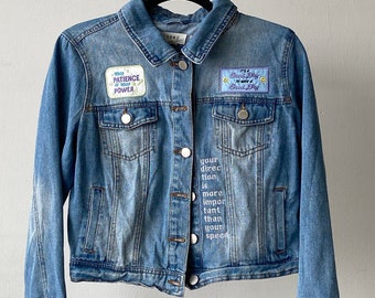 Embroidered light wash denim jacket with patches