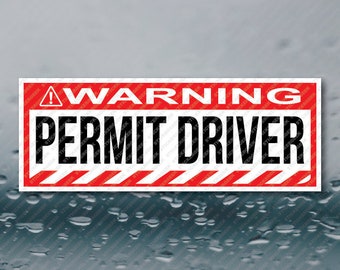 May include: Red and white warning sign with black text that reads "WARNING PERMIT DRIVER". The sign has a black exclamation point and diagonal red and white stripes.