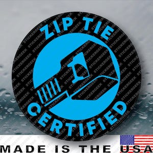 May include: A circular sticker with a black background and a bright blue graphic of a zip tie in the center. The text "ZIP TIE" is arched across the top and "CERTIFIED" is arched across the bottom in bold blue capital letters.