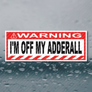 May include: A rectangular sticker with a red and white warning design. The top of the sticker reads "WARNING" in white capital letters on a red background. Below, the text "I'M OFF MY ADDERALL" is in bold black letters.